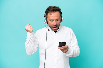 Telemarketer caucasian man working with a headset isolated on blue background surprised and sending a message