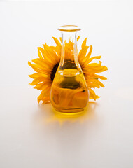Sunflower Oil In A Clear Bottle Beside A Bright Sunflower blossom