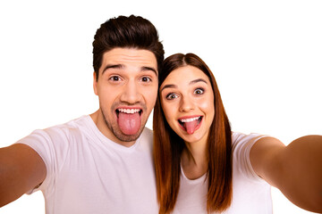 Self-portrait of his he her she two nice attractive lovely stylish cheerful cheery comic playful people husband wife showing tongue out isolated over vivid shine bright yellow background