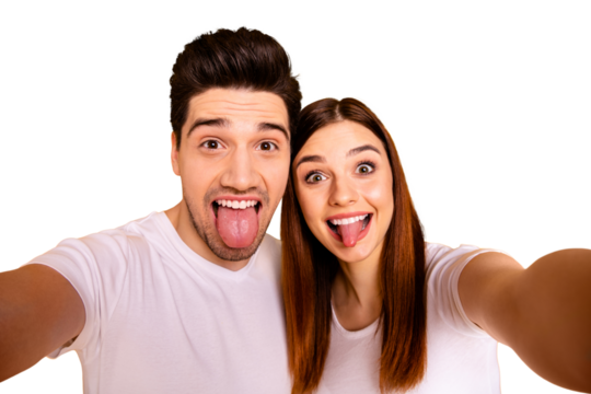 Self-portrait of his he her she two nice attractive lovely stylish cheerful cheery comic playful people husband wife showing tongue out isolated over vivid shine bright yellow background
