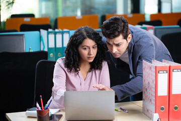 Professional Employees Discuss Data Working On Laptop