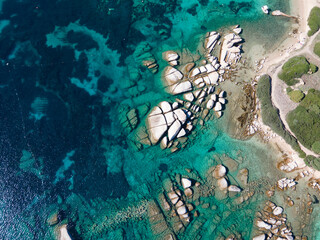 Granite rocks immersed in crystal-clear turquoise waters at Capo Testa, Sardinia, creating a stunning natural seascape perfect for exploration and photography.