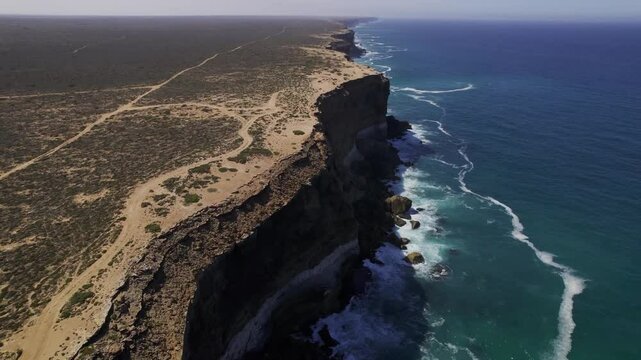 Dorne shot of the edge of Bunda cliffs in Australia following an eagle flying over the ocean