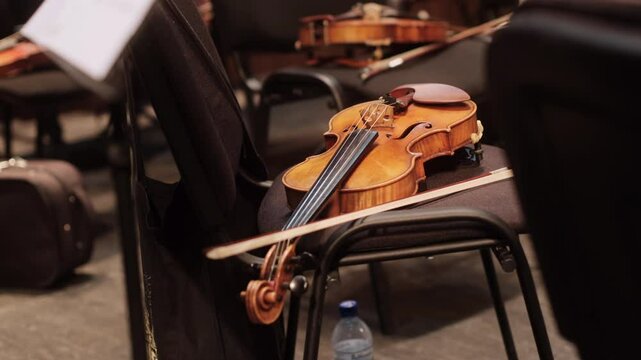 A violin resting on a chair during a rehearsal break in a classical music performance setting