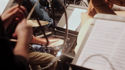 A focused view of the percussion section the snare drum and triangle in an orchestra during a symphony performance