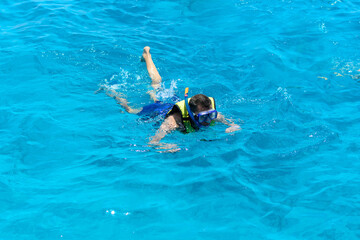 Man snorkeling in vibrant blue ocean water. Enjoy the crystal clear waters and underwater world