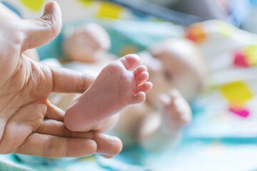 Adorable baby's tiny foot held gently in a loving hand.  Sweet newborn image!