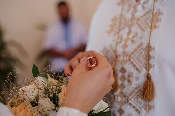 Wedding Ceremony with Bride Holding Gold Ring and Bouquet