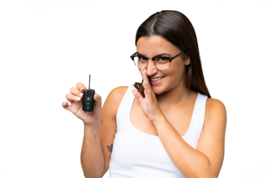 Young caucasian woman holding car keys isolated on green chroma background background whispering something