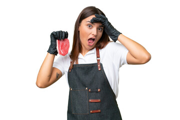Butcher woman wearing an apron and serving fresh cut meat isolated on green chroma background doing surprise gesture while looking to the side