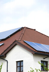 Building with installed solar panels on roof. Alternative energy source, detailed, with white tones