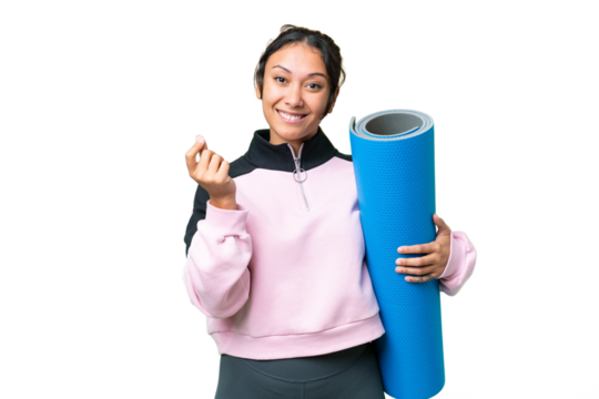 Young sport woman going to yoga classes while holding a mat over isolated chroma key background making money gesture