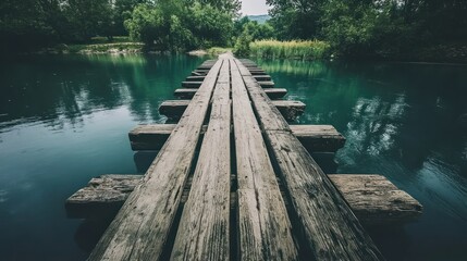Fototapeta premium Serene Wooden Bridge Over Teal River in Lush Green Forest