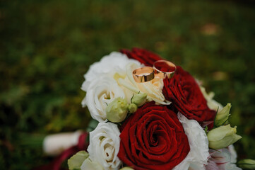 Wedding Rings on a Bouquet of Elegant Red and White Roses