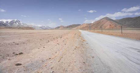 Asphalt road of the Pamir Highway in the valley of the Tien Shan Mountains in Tajikistan in the...