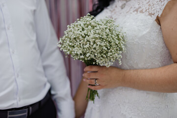 Bride Holding a Delicate Baby's Breath Bouquet in Elegant Wedding Attire
