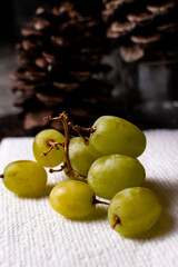 A side view of grapes on top of a white napkin. 