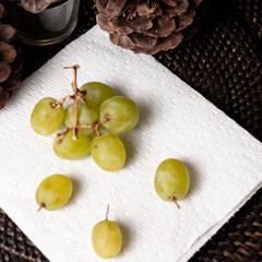 A top view of green grapes on a white napkin.