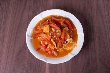 Scrambled eggs with tomatoes on a white plate