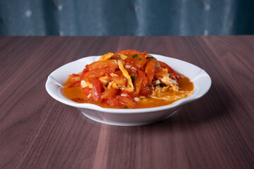 Scrambled eggs with tomatoes on a white plate