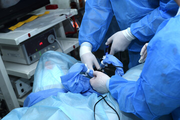 urological examination with an endoscope, lithotripsy, urological operating room, surgeon in a blue...