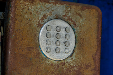 Close up of old and rusty doorbell on a blue background.