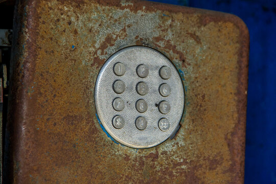 Close up of old and rusty doorbell on a blue background.