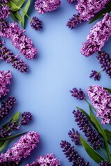 Lavender-hued background with elegant spring flowers arranged neatly around the edges. Flat lay.