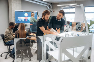 Modern technology. Standing. People are in the office by the 3d printer