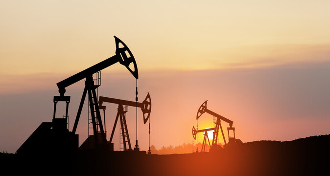 Oil drilling derricks at desert oilfield. The change in oil prices caused by the war. Oil price cap concept.