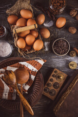 Assorted baking ingredients on wooden vintage table, in brown tone