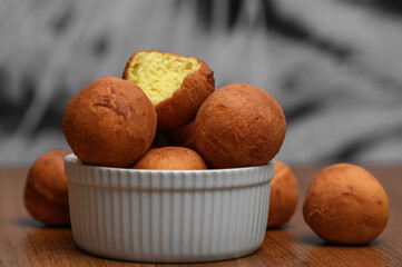 Mini pączki wysypują się z miski, apetyczne smażone ciastka