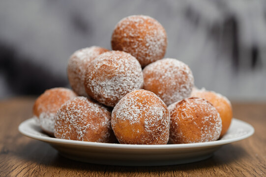 Mini pączki leżą ułożone w piramidę na talerzu z bliska