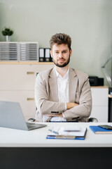 Successful young male businessman giving victory thumbs up to show success and motivation.