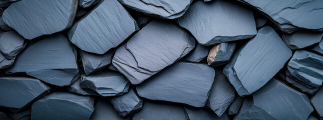Fototapeta premium Textured black slate rock background with layered stones, ideal for design. dark hues and natural patterns create striking visual appeal