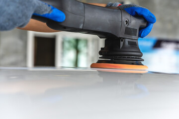 Car care worker using hand tools vanish car in car wash service shop