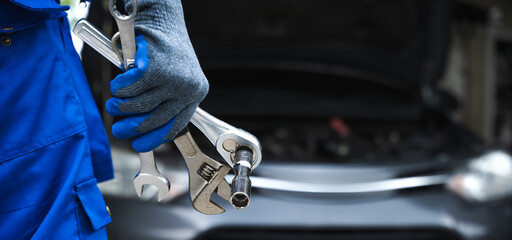 Close up car mechanic hand holding mechanic tools working in auto repair service shop
