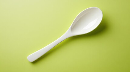 A ceramic spoon with a smooth finish displayed on a lime green backdrop