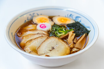 Japanese noodle soup ramen with egg and pork in black ramen bowl for Japanese food style.