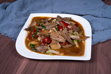 Pork liver with hot and sour pickled peppers on a white plate