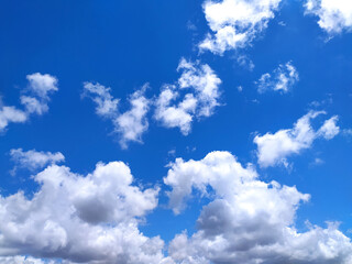 Obraz premium Clear blue sky texture and white fluffy cloud nature background. The sun shines bright in the daytime in summer