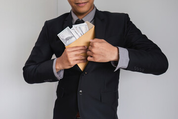 Businessman Hiding Money in Envelope Symbolizing Corruption and Financial Misconduct in Corporate Environment