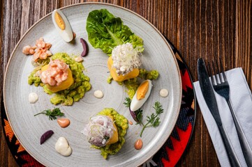 Gourmet dish with avocado, seafood, and eggs.