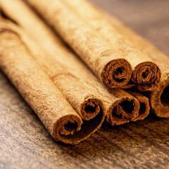 Cinnamon sticks on a wooden background close up.