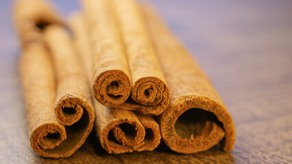 Cinnamon sticks on a wooden background close up.