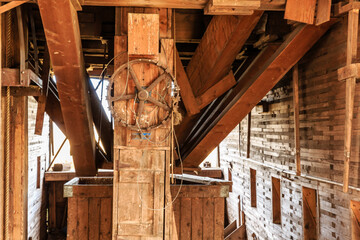 A large wooden structure with a wooden door and a wooden wheel