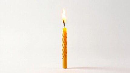 a burning yellow candle on a white background