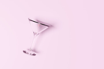 Empty martini cocktail glass laying on a pink background. Illustration of the concept of sobriety and alcoholic free