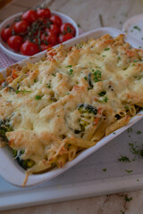 Vegetarian vegetable pasta casserole with cheese crust in a white baking dish
