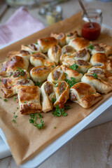 Puff pastry filled with bratwurst or fried sausage and served as a party wreath
